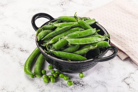 Sweet young green peas heap in the bowlの写真素材