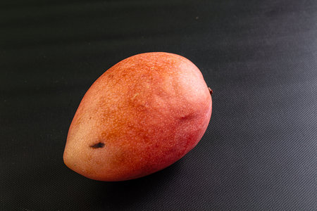Whole ripe sweet tropical red mango fruitの写真素材
