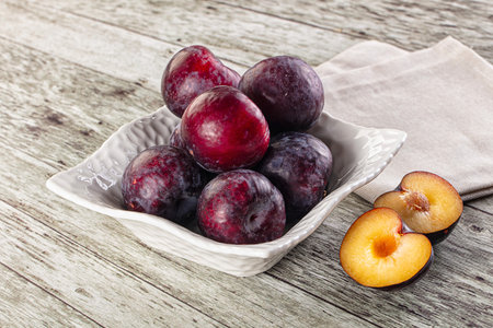 Ripe sweet juicy plum heap in the bowlの写真素材