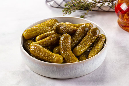 Marinated canned green cornichon cucumbers in the bowlの写真素材