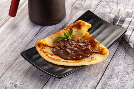 Sweet pancake with chocolate paste for breakfastの写真素材
