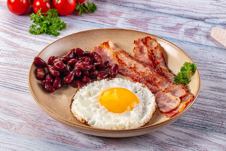English breakfast with egg, bean and fried baconの写真素材