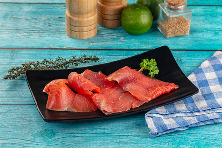 Delicous sliced salmon fillet ready to eat in the plate served thyme