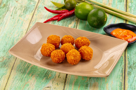 Fried crispy yellow cheese balls with sauce