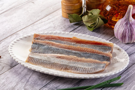 Marinated salted herring fillet slices in the plate