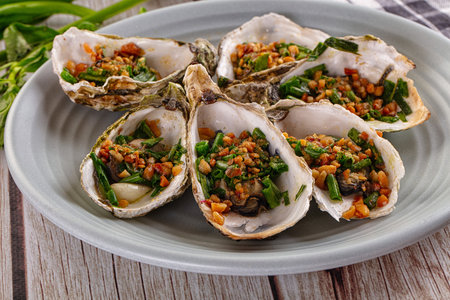 Grilled oysters with green onion and peanutの写真素材