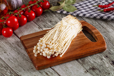 Raw organic fresh enoki mushrooms over board