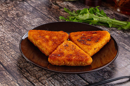 Fried golden fish cutlets triangles in the plate