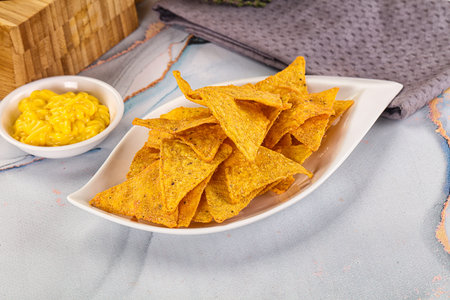 Corn nachos chips with cheese dip sauce