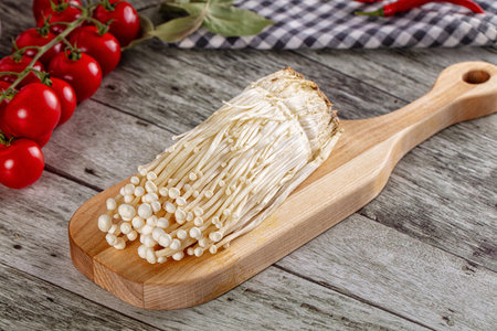 Raw organic fresh enoki mushrooms over board