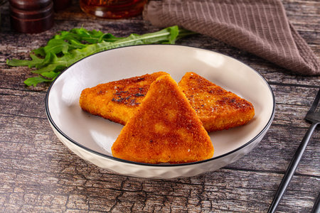 Fried golden fish cutlets triangles in the plate