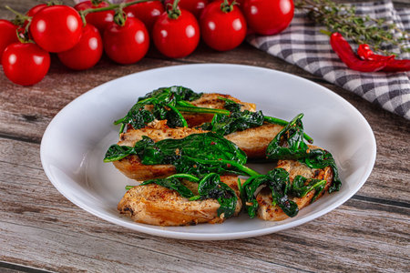 Roasted chicken breast slices with green spinachの写真素材