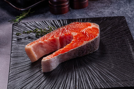 Raw salmon fish fillet steak over board for cooking