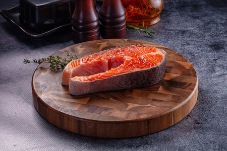 Raw salmon fish fillet steak over board for cooking