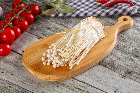 Raw organic fresh enoki mushrooms over board