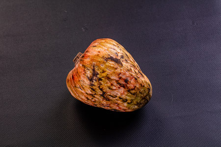 Single ripe exotic cherimoya fruit on a background. Top-down view with soft light highlighting the...