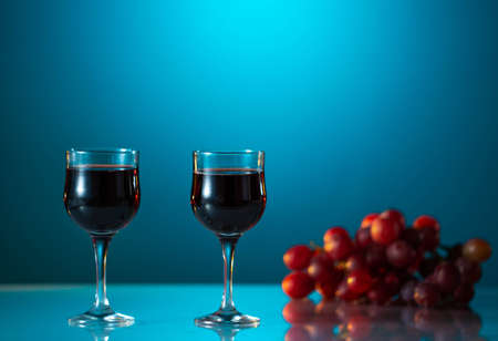 Two glasses of wine on a beautiful blue background. holiday moodの写真素材
