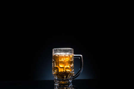 Frosty glass of light beer set isolated on a black backgroundの写真素材