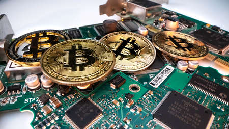 cryptocurrency mining concept with golden bitcoin coins next to a computer performant video card...