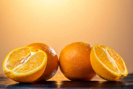 Ripe oranges lie on a table with a reflective surface. the taste of summer. summer mood. health. proper nutritionの写真素材