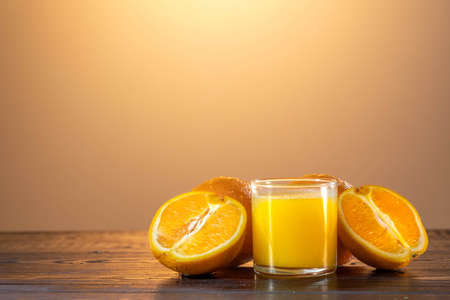 Orange juce, half of orange on the wooden table. Summer mood. close up shot.の写真素材