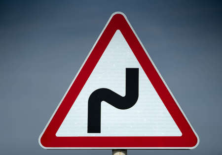 Road sign serpentine. dangerous turn. close up shotの写真素材