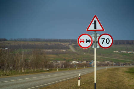road sign overtaking is prohibited. road sign speed limit 70 km h. road sign turn right midle shotの写真素材