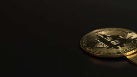 Crypto currency. Blockchain technology, bitcoin miningTwo gold BITCOIN BTC on the black table. Slow panorama from left to right.の写真素材