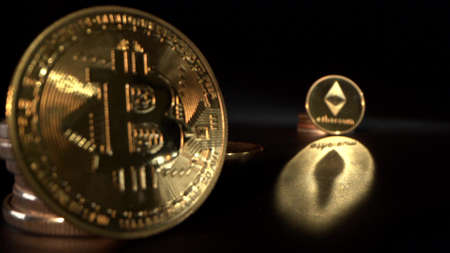 Gold Bitcoin BTC and gold Etherium with black background with reflection on the surface. Trading. Halving.の写真素材