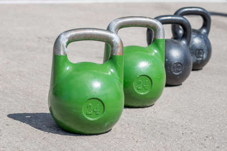 black and green weights are standing on the pavementの写真素材