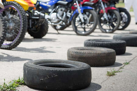 a number of old tires lies on the road under the bright summer sun