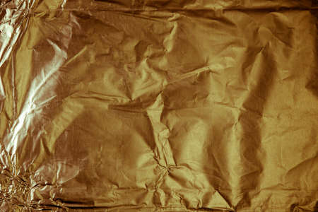 background of crumpled glossy metallic foil closeupの写真素材
