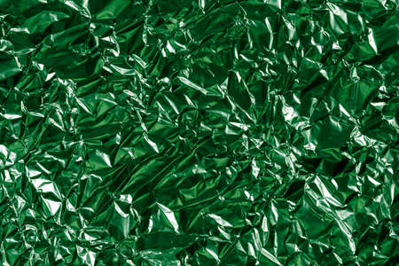 background of crumpled glossy metallic foil closeupの写真素材