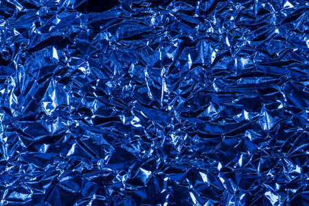 background of crumpled glossy metallic foil closeupの写真素材