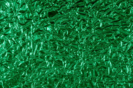 background of crumpled glossy metallic foil closeupの写真素材