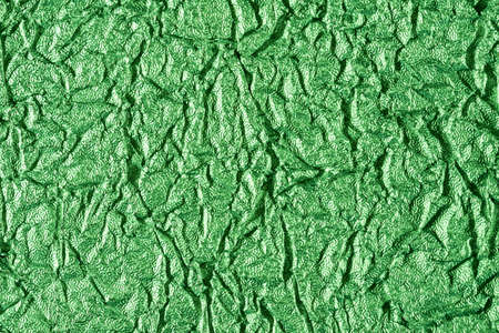 background of crumpled glossy metallic foil closeupの写真素材