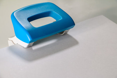 Paper Hole Puncher on White Sheet - Office Supply Close-Upの写真素材