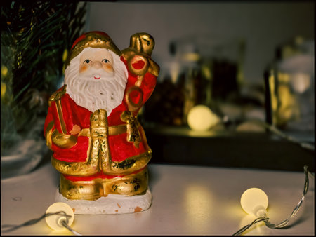 Santa Claus Figurine in Cozy Christmas Setting with String Lights and Decorの写真素材