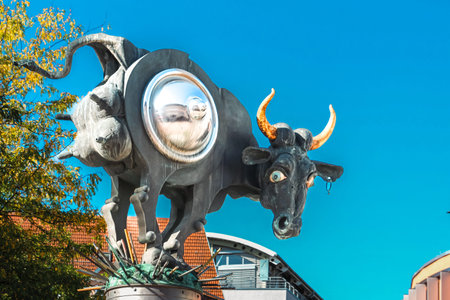 Surreal airborne cow sculpture with reflective sphere and vivid hornsの写真素材