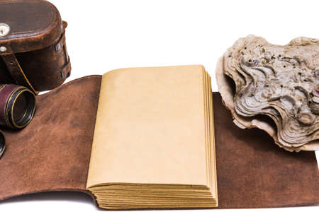 Opened old leather book with sea shell  isolated on white backgroundの写真素材