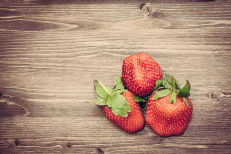 Fresh strawberries on old wooden background with copy spaceの写真素材