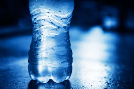 Plastic bottle of  pure water with condensate drops and back lightの写真素材