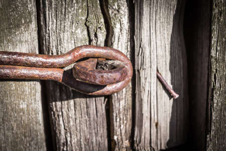 Old rusty latch on weathered wooden surfaceの写真素材