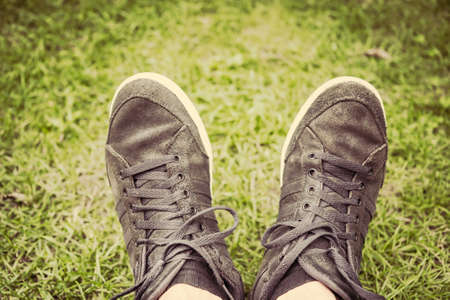 Teenager Feet in sneakers in the green grassの写真素材