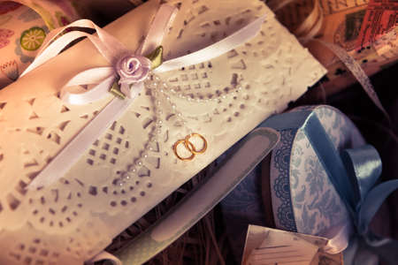Vintage wedding invitation envelope with ribbon among git boxesの写真素材