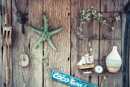 Vintage holidays still life with rope, starfish, compass and bottle on old wooden backgroundの写真素材