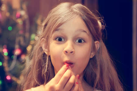 Amazed child looking at camera during Christmas holidays after receiving Christmas giftの写真素材