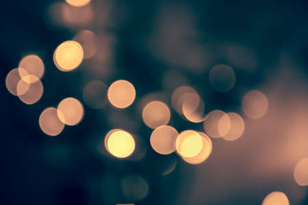 Blue toned blurred chrismas background with street lights on the night street in vintage styleの写真素材