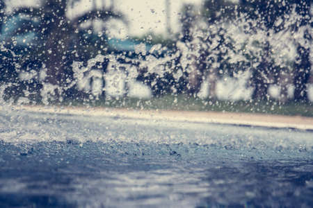 Splashing blurred and defocused swimming pool background with palm trees on backgroundの写真素材