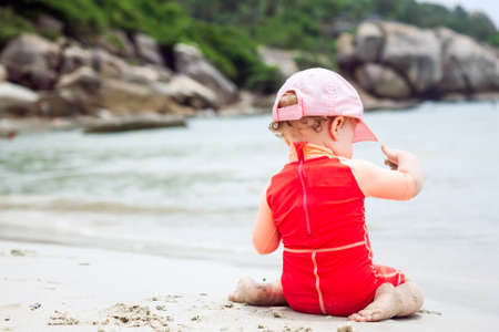 Baby playing on beach with copy space during summer holidaysの写真素材